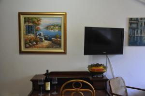 a room with a table with a television on a wall at Apartments Vujošević in Kotor