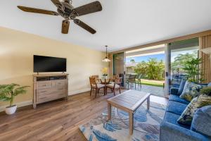 a living room with a blue couch and a ceiling fan at Maui Eldorado E106 in Kahana