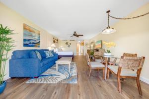 a living room with a blue couch and a dining room at Maui Eldorado E106 in Kahana