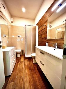 a bathroom with a shower and two sinks and a toilet at Welcome Traveller VILLA ARIGONI in Garda