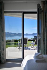 a bedroom with a view of the ocean through a sliding glass door at "Babe" Beachfront Residence in Sukošan