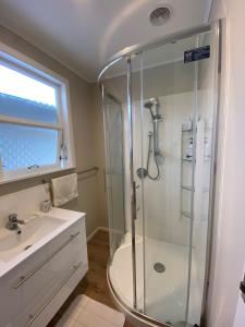 a bathroom with a shower and a sink at Birch Court - Harakeke in Whanganui