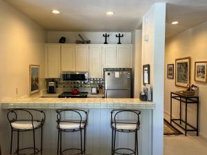 a kitchen with a counter with three bar stools at SV Wildflower Condo 3 Bed 3 Bath w SV INN pool access- No PETS! in Sun Valley