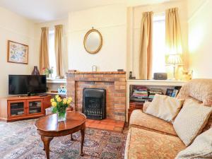 a living room with a couch and a fireplace at The Old Grocery in Hollingwood