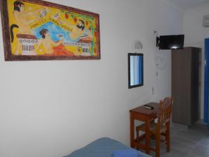 a room with a painting on the wall and a table at Studios Apartments Kapetanios in Perissa