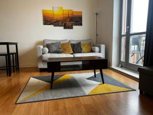 a living room with a couch and a coffee table at River View Apartment - Central Dundee - Free Private Parking - Sky & TNT Sports - Lift Access - Superfast WIFI - Quiet Neighbourhood - 2 Bathrooms - Amazing Views - Balcony & Courtyard - Long Stays Welcome in Dundee