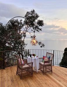 una mesa con sillas y una lámpara de araña en una terraza en Luxury Villa Ciao Cocoa, en Grimaldi