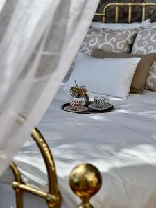 a white bed with a tray with two plants on it at Luxury Villa Ciao Cocoa in Grimaldi