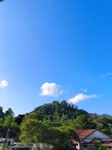 a mountain with trees and a blue sky at GOLDEN GUEST HOUSE KUANTAN in Kuantan