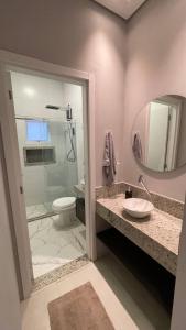 bagno con doccia, lavandino e specchio di Casa com piscina 1 Quarto a Rondonópolis