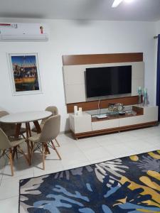 a living room with a television and a table and chairs at Casa Duplex Aconchegante de Frente para o Mar in Porto Seguro