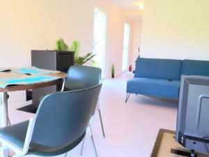 sala de estar con sofá azul, mesa y sillas en L'îlot - Cosy moderne avec parking, en Bourges