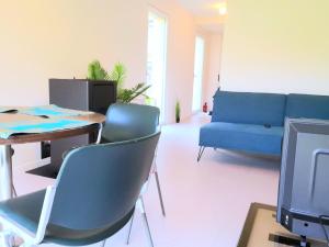 - un salon avec un canapé bleu, une table et des chaises dans l'établissement L'îlot - Cosy moderne avec parking, à Bourges