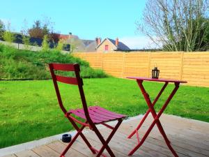 a red chair and a table in a yard at L'îlot - Cosy moderne avec parking in Bourges