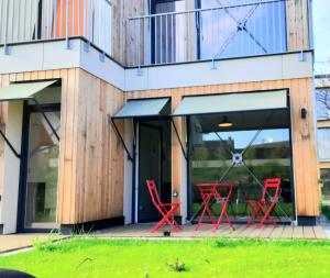 布爾日的住宿－L'îlot - Cosy moderne avec parking，前廊上带红色椅子的房子