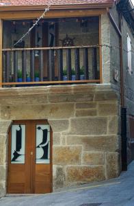 a stone building with two doors and a balcony at Pepita Carnera in Marín