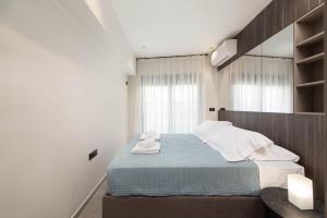 a small bedroom with a bed and a mirror at 30 Senses Luxury Apartment Insight in Ialyssos