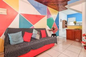 a couch in a room with a colorful wall at Cantinho da Alegria in Rio de Janeiro