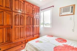 1 dormitorio con 1 cama y un gran armario de madera en Cantinho da Alegria en Río de Janeiro