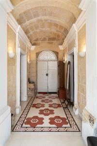 a hallway with a large rug in front of a door at Traditional & Modern Maltese Townhouse - Rooftop Terrace and Sea Views, close to Birgu Waterfront in Cospicua