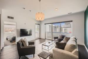 a living room with a couch and chairs and a tv at Modern 2BR Condo Walk to all RiNo Attractions in Denver