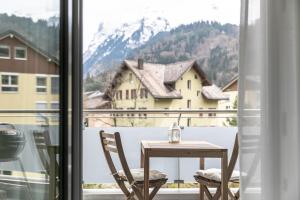 a table and chairs in front of a window at Spirit Apartments - Studio #3 - Balkon - Parkplatz in Engelberg