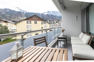d'un balcon avec une table en bois et un canapé. dans l'établissement Spirit Apartments - Studio #3 - Balkon - Parkplatz, à Engelberg