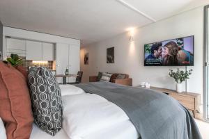 um quarto com uma cama e uma televisão na parede em Spirit Apartments - Studio #3 - Balkon - Parkplatz em Engelberg