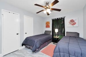 a bedroom with two beds and a ceiling fan at Everything under 5 min. The Woodlands TX. Fully Equipped for Long stays as well. in Shenandoah