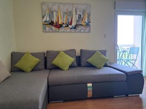 a couch with yellow pillows in a living room at Apartment Penić in Kaštela