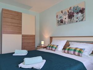 a bedroom with a large bed with towels on it at Apartment Penić in Kaštela