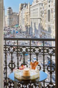 a table with food on a balcony with a view of a city at NH Collection Madrid Gran Vía in Madrid