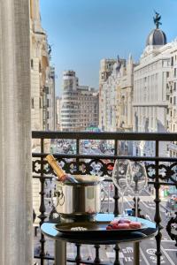 a pot on a table on a balcony overlooking a city at NH Collection Madrid Gran Vía in Madrid