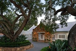 an exterior view of a house with trees at Mount Grace Hotel & Spa in Magaliesburg