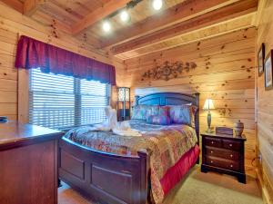 a bedroom with a bed in a log cabin at Misty Mountain Hideaway, 3 Bedrooms, Sleeps 10, Pool Access, WiFi in Pigeon Forge