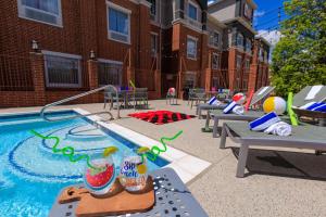 a swimming pool with tables and chairs next to a building at Best Western Plus Duncanville/Dallas in Duncanville