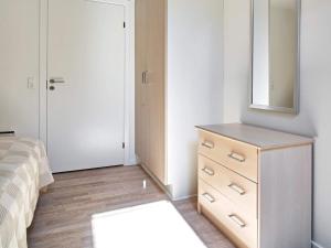 a bedroom with a dresser and a mirror at Holiday home Nexø XLI in Neksø