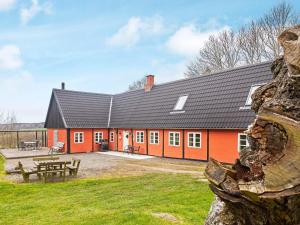 een oranje gebouw met een picknicktafel ervoor bij Holiday home Nexø XLIII in Neksø