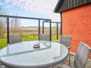 een glazen tafel en stoelen op een patio bij Holiday home Nexø XLIII in Neksø