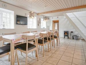 een eetkamer met een tafel en stoelen en een open haard bij Holiday home Nexø XLIII in Neksø