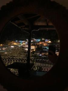 une personne prenant une photo d'une ville la nuit dans l'établissement Timo's Guest House, à Berat