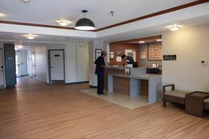 un homme debout à un comptoir dans un bureau dans l'établissement Candlewood Suites Sheridan, an IHG Hotel, à Sheridan