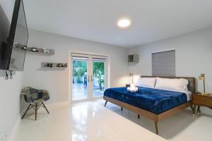 a bedroom with a blue bed and a chair at Cool Villa Northwest Miami BY THE GLAMHOMES in Miami +15 photos