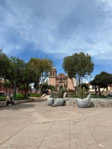 a building in the background with cacti in a park at CASA SANTIAGO in Cusco