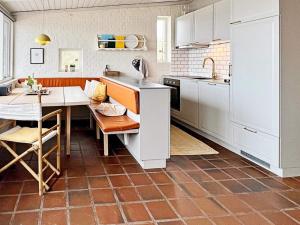 ヘンネ・ストランドにある5 person holiday home in Henneのキッチン(白いキャビネット、テーブル、シンク付)