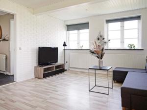 een woonkamer met een bank en een tv bij Holiday home Aakirkeby XLV in Åkirkeby