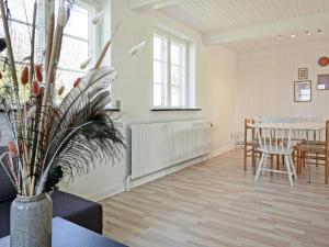 - un salon avec une table et un vase fleuri dans l'établissement Holiday home Aakirkeby XLV, à Åkirkeby