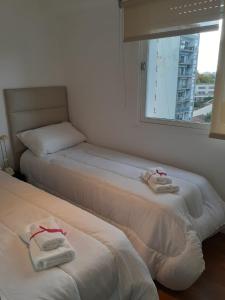 Dos camas en una habitación con toallas. en Puerto de Olivos 3 ambientes in 