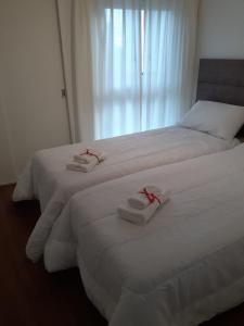 2 Betten in einem Hotelzimmer mit Handtüchern darauf in der Unterkunft Puerto de Olivos 3 ambientes in Olivos