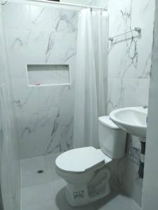 ein weißes Badezimmer mit Toilette und Waschbecken in der Unterkunft HABITACIÓN CERCA AL CENTRO DE SANTA MARTA in Santa Marta